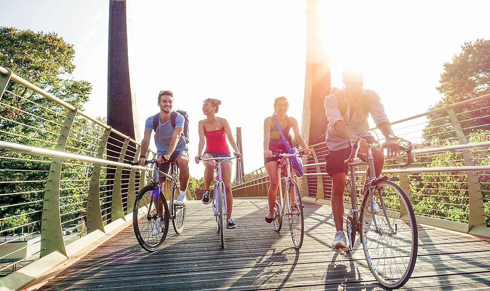 A group of people riding bicycles on a bridge.